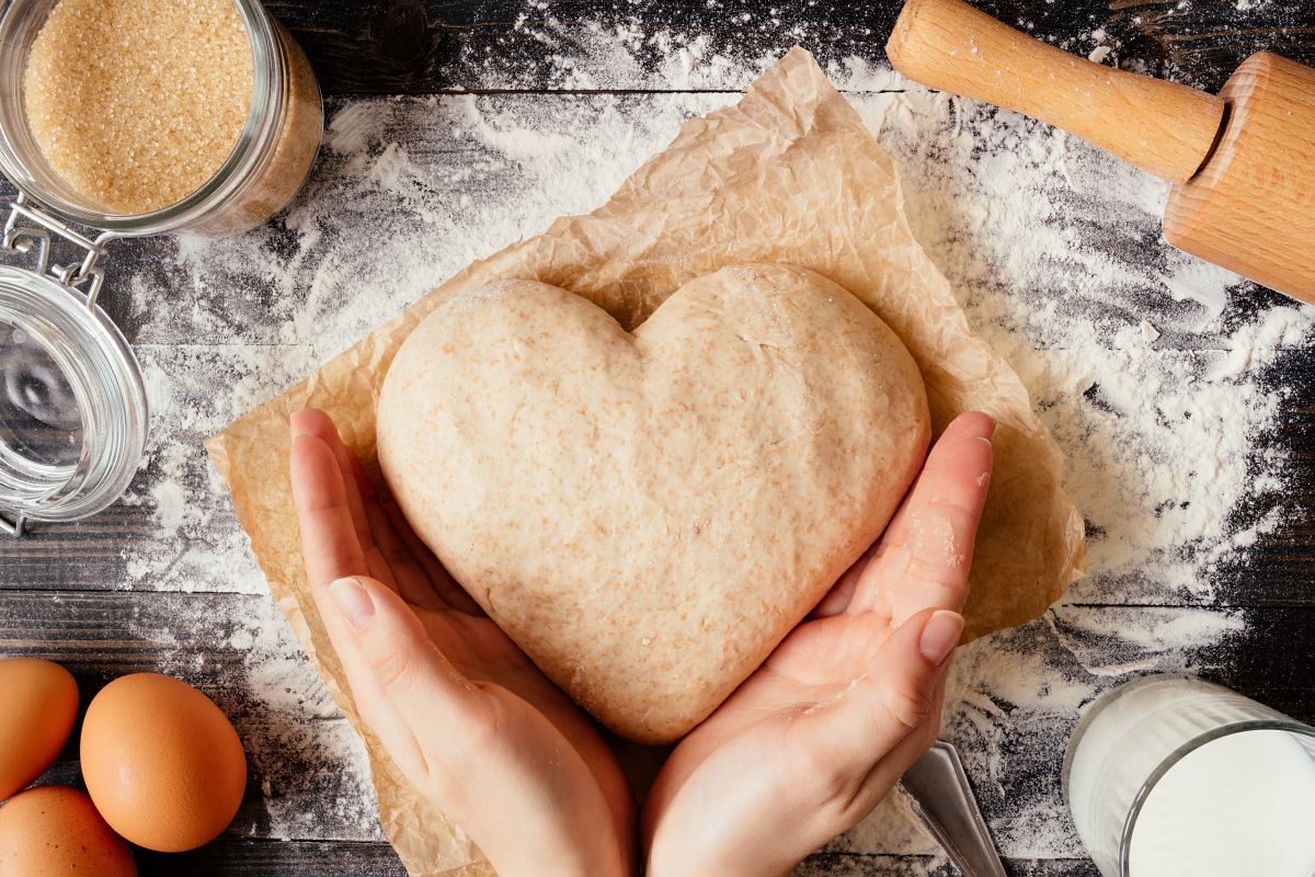 Female,Hands,Holding,Dough,In,Heart,Shape,Top,View.,Baking