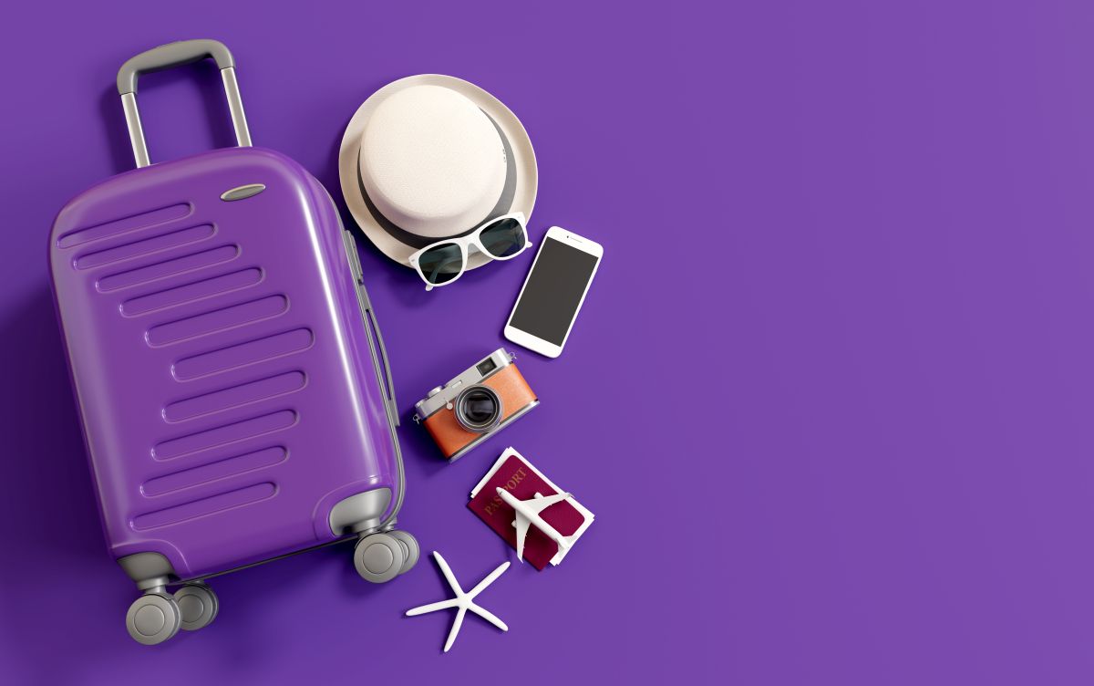 Flat,Lay,Purple,Suitcase,With,Traveler,Accessories,On,Purple,Background.