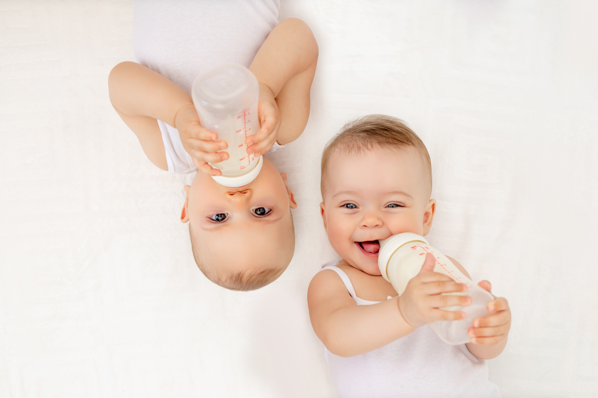Twin,Babies,Boy,And,Girl,With,A,Bottle,Of,Milk